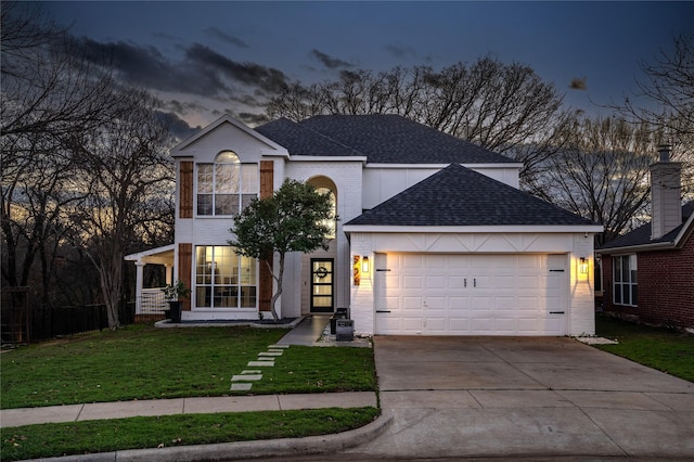 traditional-style house featuring a garage, driveway, brick siding, roof with shingles, and a front yard