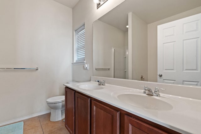 full bath featuring toilet, tile patterned flooring, double vanity, and a sink