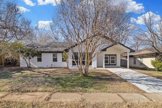 ranch-style home with concrete driveway and a front yard