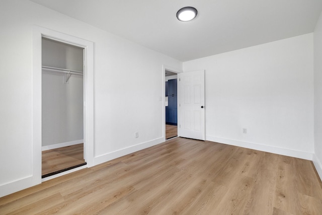 unfurnished bedroom with light wood finished floors, a closet, and baseboards