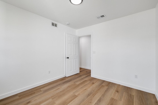 unfurnished room with light wood-type flooring, baseboards, and visible vents