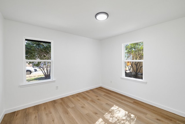 empty room with light wood-style floors and baseboards