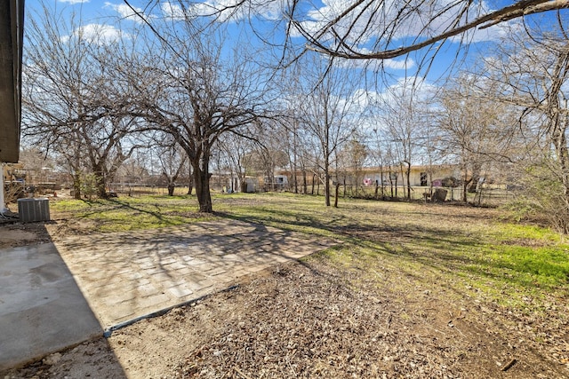 view of yard with central air condition unit and a patio area