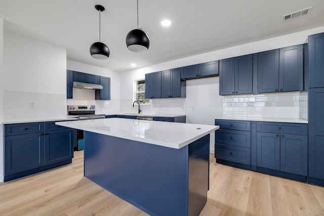 kitchen with visible vents, a center island, stainless steel electric range, light countertops, and under cabinet range hood