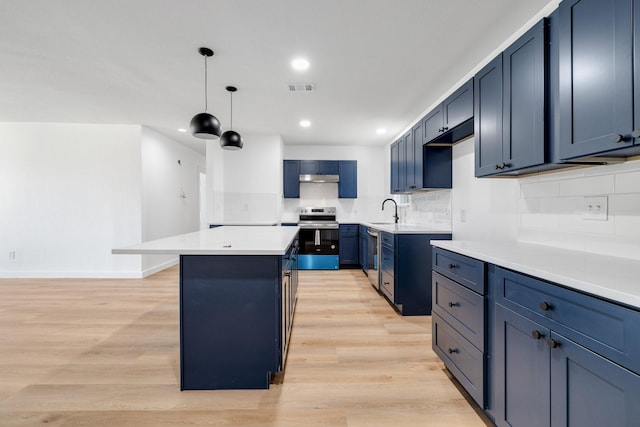 kitchen with stainless steel appliances, a sink, visible vents, light countertops, and a center island