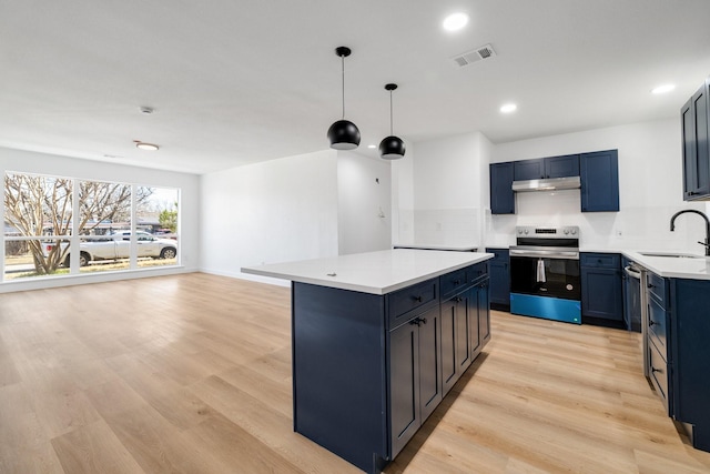 kitchen featuring stainless steel electric stove, light countertops, visible vents, a sink, and under cabinet range hood