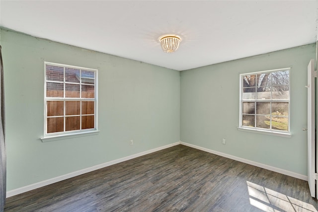 unfurnished room featuring dark wood-style floors and baseboards