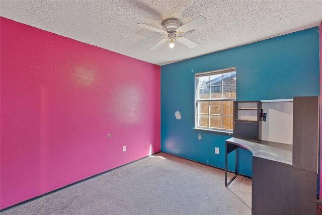 unfurnished office with light carpet, ceiling fan, and a textured ceiling