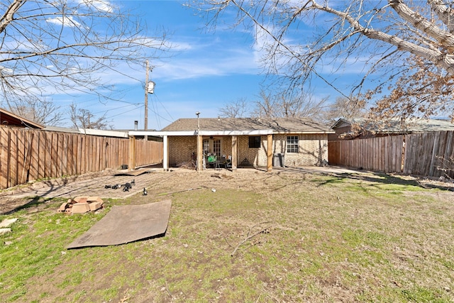 rear view of house with a patio area, brick siding, a lawn, and a fenced backyard