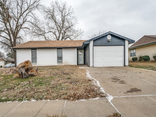 ranch-style home featuring driveway, an attached garage, and brick siding