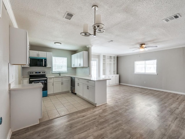 kitchen with light countertops, appliances with stainless steel finishes, open floor plan, white cabinets, and a peninsula