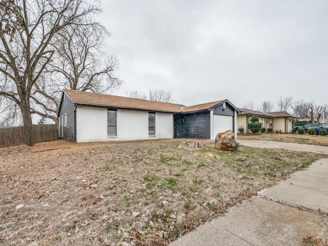 single story home with a garage, driveway, and fence