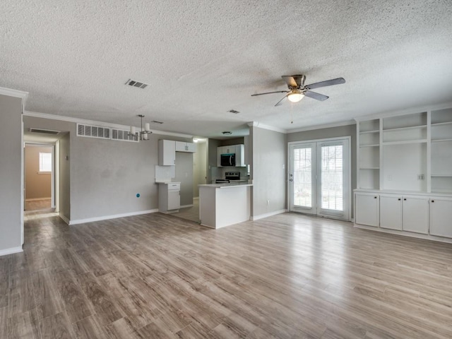 unfurnished living room featuring a ceiling fan, visible vents, plenty of natural light, and light wood-style flooring