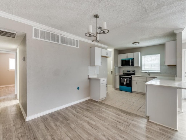 kitchen featuring range with electric cooktop, light wood-style flooring, light countertops, white cabinetry, and pendant lighting