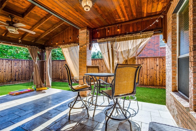 view of patio / terrace with a fenced backyard, a ceiling fan, and outdoor dining space