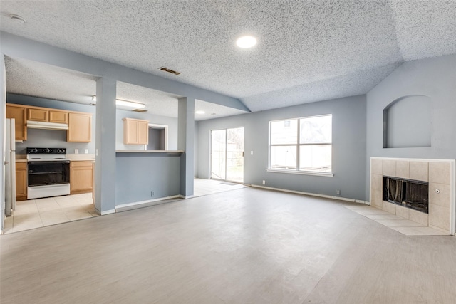 unfurnished living room with baseboards, visible vents, light wood finished floors, and a tiled fireplace