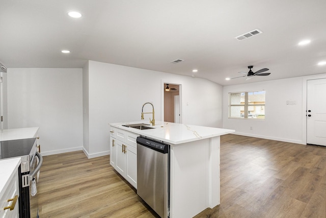 kitchen with a sink, white cabinets, open floor plan, appliances with stainless steel finishes, and an island with sink