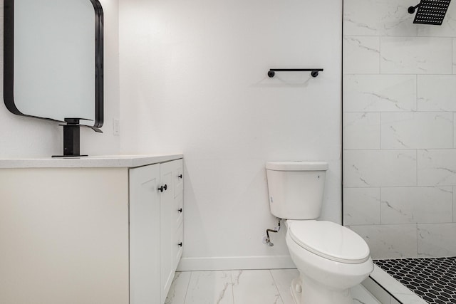 full bathroom featuring marble finish floor, toilet, a tile shower, vanity, and baseboards