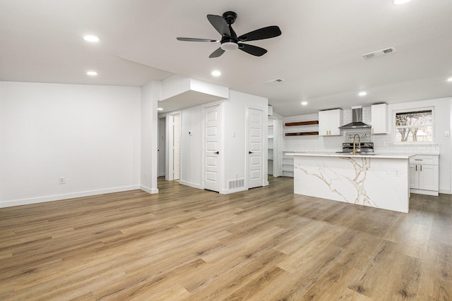 unfurnished living room with baseboards, light wood finished floors, visible vents, and recessed lighting