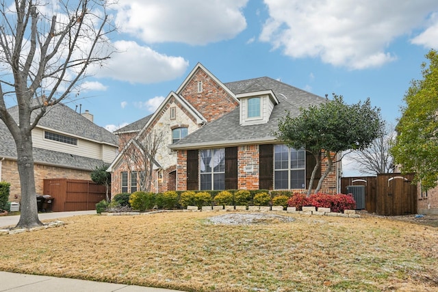 view of front of house with a front yard, fence, and brick siding