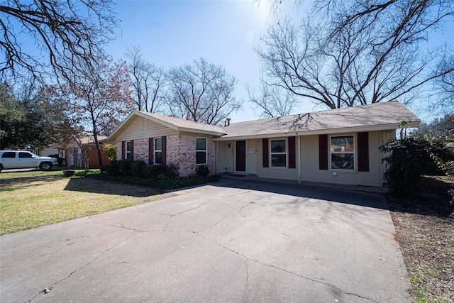 single story home with a front yard, concrete driveway, and brick siding