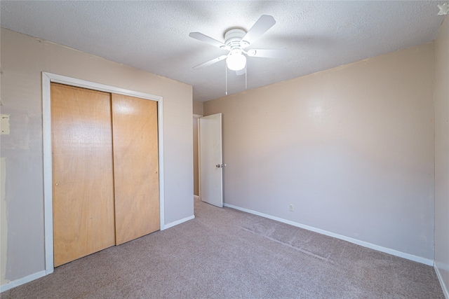 unfurnished bedroom featuring a textured ceiling, a closet, carpet, and baseboards