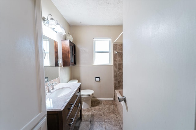 full bathroom featuring wainscoting, toilet,  shower combination, a textured ceiling, and vanity