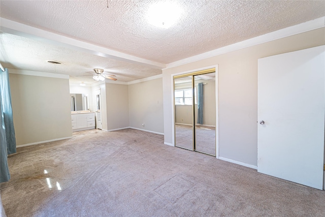 unfurnished bedroom with light carpet, a closet, visible vents, and a textured ceiling