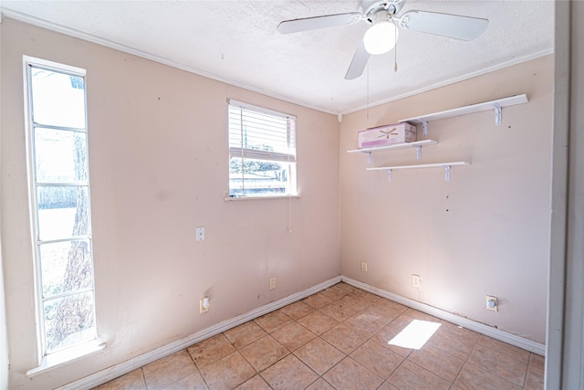 empty room with a textured ceiling, ceiling fan, and baseboards