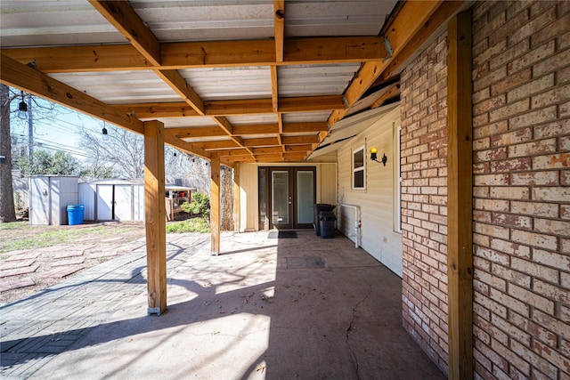 view of patio with a storage shed, an outbuilding, and french doors