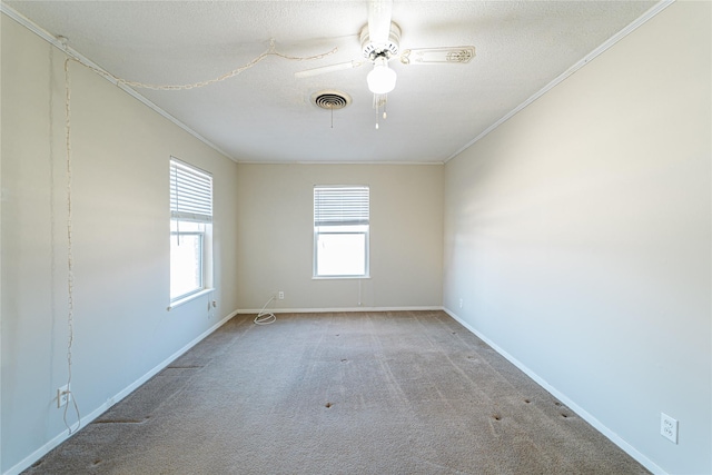 spare room featuring crown molding, visible vents, carpet flooring, a textured ceiling, and baseboards