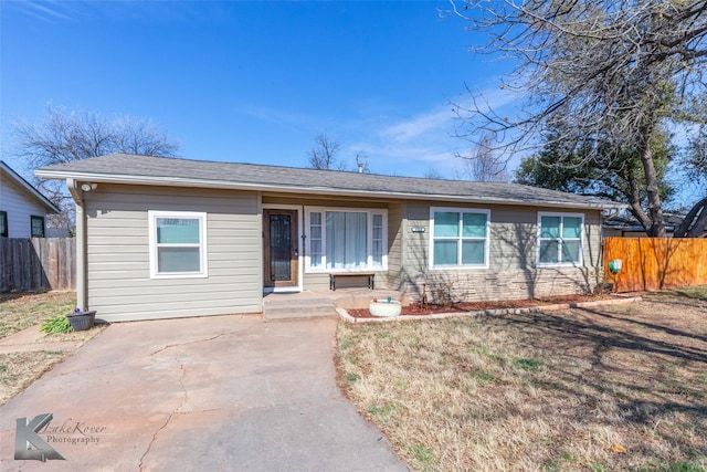 ranch-style home featuring fence