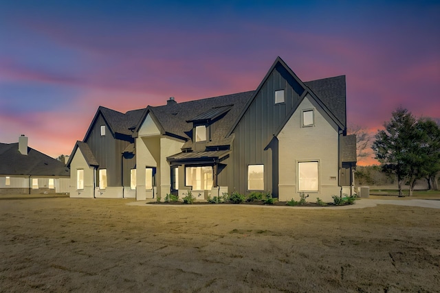 modern inspired farmhouse featuring metal roof, central AC unit, board and batten siding, a front lawn, and a standing seam roof