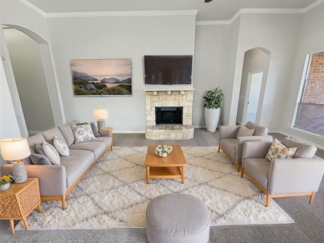 living room featuring arched walkways, a fireplace, baseboards, and crown molding