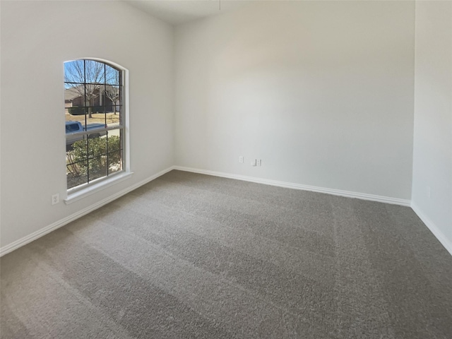 unfurnished room with carpet flooring and baseboards