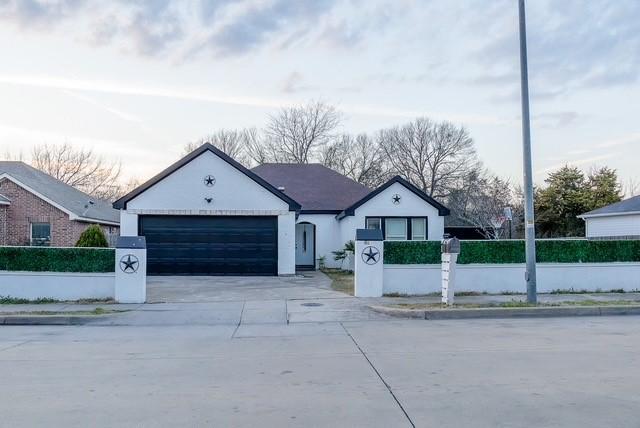 view of front of property featuring a fenced front yard, concrete driveway, an attached garage, and stucco siding