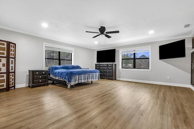 bedroom with baseboards, visible vents, wood finished floors, crown molding, and recessed lighting