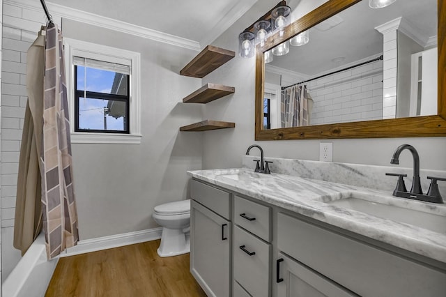 full bathroom featuring wood finished floors, ornamental molding, a sink, and toilet