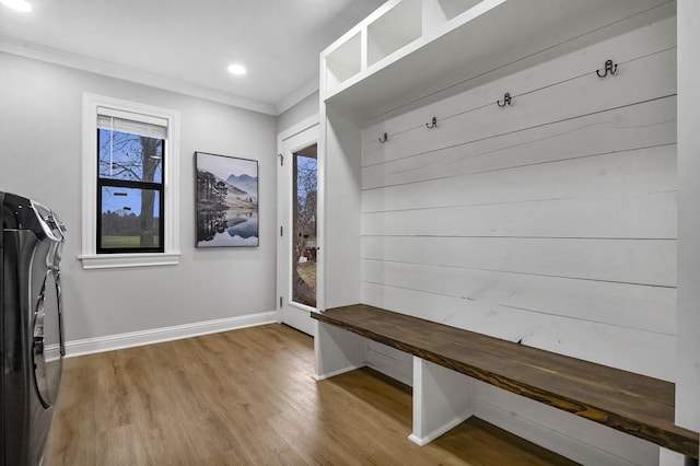 mudroom featuring ornamental molding, washer and clothes dryer, baseboards, and wood finished floors