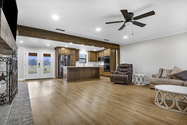 living room featuring light wood-style floors, french doors, visible vents, and plenty of natural light