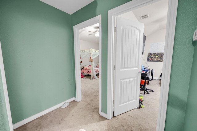 corridor featuring light carpet, baseboards, and visible vents