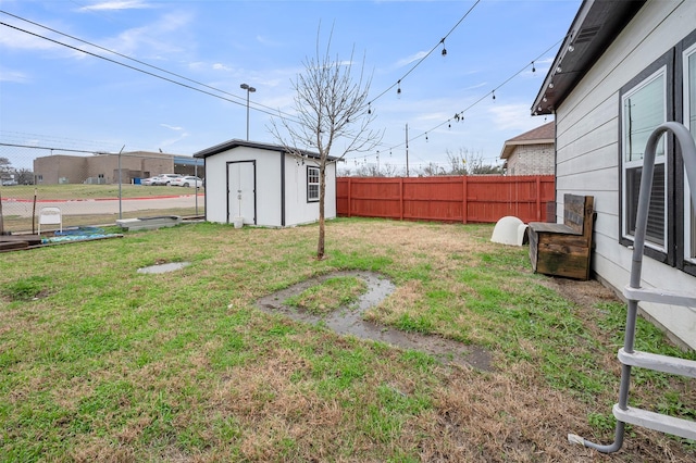 view of yard with a fenced backyard, an outdoor structure, and a shed