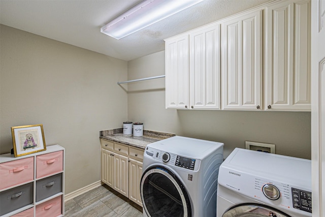 laundry room featuring baseboards, cabinet space, and washer and dryer