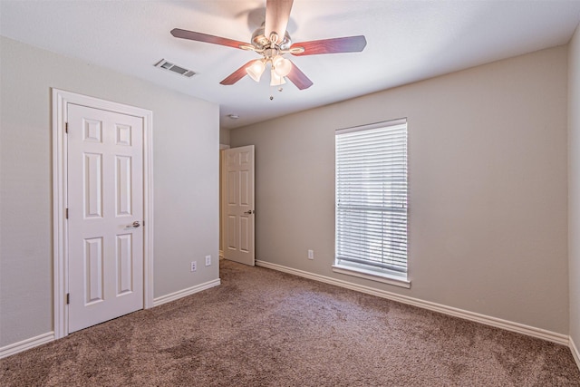 unfurnished bedroom featuring carpet, visible vents, ceiling fan, and baseboards