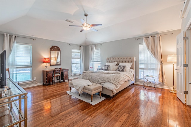 bedroom with vaulted ceiling, wood finished floors, visible vents, and baseboards