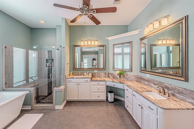 bathroom featuring ceiling fan, vanity, a soaking tub, a shower stall, and tile patterned floors