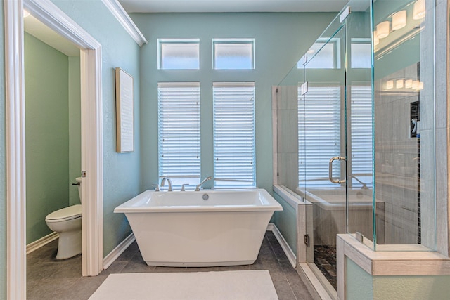 full bathroom featuring baseboards, toilet, tile patterned floors, a freestanding bath, and a shower stall