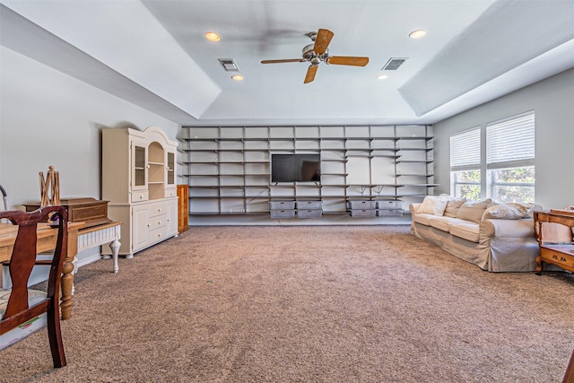 carpeted living room featuring a tray ceiling, visible vents, and recessed lighting