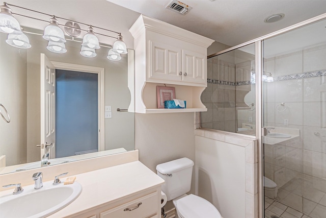 full bath with toilet, vanity, a shower stall, and visible vents