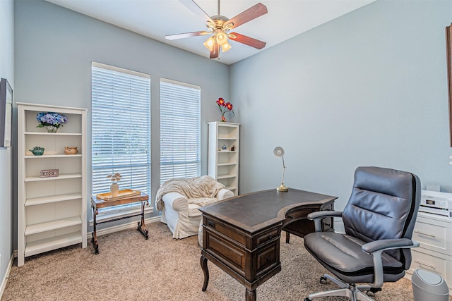 office featuring a ceiling fan, light carpet, and baseboards